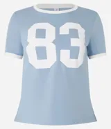 Remera baby look celeste con cuello y mangas con ribete blanco, y estampa frontal con el número 83 en blanco.