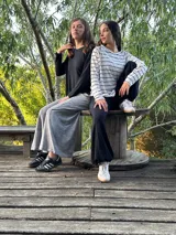 Remerón negro de manga larga, corte oversize con espalda más larga, tajos laterales y bajo redondeado.