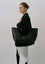 Bolso shopper grande de cuero negro, con doble asa de mano y asa de hombro. Tiene cierre magnético y forro interior.