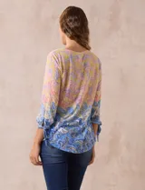 Blusa de modal estampada con cuello redondo y escote en V con aplique metálico. Mangas 3/4 con lazo.
