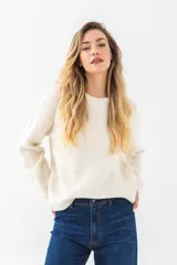 Buzo de punto liso color beige, con cuello a la base y diseño holgado.
