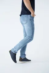 Pantalón jean celeste de corte recto, con cintura regular y tiro medio. Tiene roturas y logo bordado.
