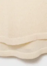 Jersey de punto fino color crema, con cuello redondo, diseño recto y mangas largas. Incluye una musculosa al tono.