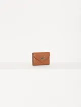 Billetera pequeña color visón, con solapa y cierre a presión. Diseño acolchado con pespuntes en forma de V y logo metálico con forma de labios.