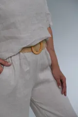 Pantalón de lino color crudo, de corte recto y tiro medio, con cinturón beige de soga incluido.