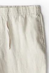 Pantalón de lino color beige, corte recto, con cintura elastizada y cordón de ajuste.