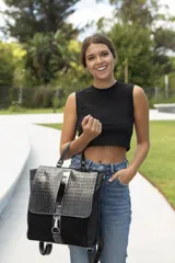 Mochila de cuero en color negro con diseño texturizado y detallado en la solapa.