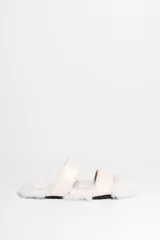 Sandalias bajas con dos tiras anchas de cuero sintético color crema y base forrada en piel sintética blanca.