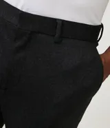 Pantalón de traje de corte super slim, color azul oscuro, confeccionado en tejido de poliviscosa con textura discreta. Presenta trabillas en la cintura, cierre de cremallera y botón, y bolsillos laterales y traseros.