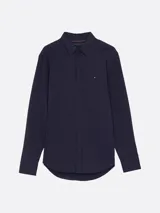 Camisa Tommy Hilfiger de manga larga azul marino, corte slim y cuello abotonado. Confeccionada en mezcla de algodón y poliéster.