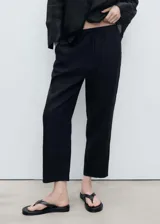 Pantalón negro de lino con cintura elástica y cordón ajustable.