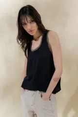 Musculosa negra de punto con cuello redondo y ribete en color beige.