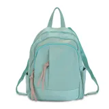 Mochila color verde agua, de tafeta, con apertura frontal, dos bolsillos frontales con cierre metálico, bolsillos internos, bolsillos laterales, bolsillo trasero y correas regulables de galón.