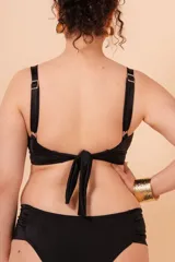 Soutien de baño negro sin aro, con breteles regulables y nudo en la espalda. Base en bajo busto para mayor contención. Detalle de aro en el centro.