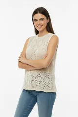 Chaleco de punto calado color crudo, sin mangas y con cuello redondo.