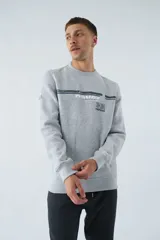 Buzo gris melange de algodón con cuello redondo, puños y cintura acanalados. Estampado frontal con el logo de la marca.