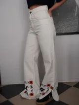 Pantalón de jean color crudo, corte recto, con estampado de caballos en los tobillos.