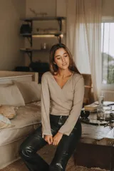 Remera negra de punto canalé con escote cruzado en V y mangas largas con puños de piel sintética con pelo.