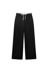 Pantalón ancho gris con textura de espiga, tiro alto, doble cintura elástica ajustable con cordón, pinzas frontales, bolsillos delanteros y falso bolsillo de vivo en la espalda.