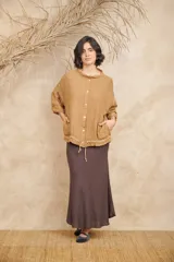 Campera color ocre de lino, con cuello mao, mangas 3/4 con puños abotonados, cierre frontal con botones y cordón ajustable en la cintura.