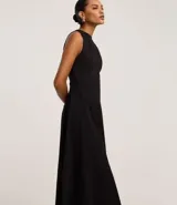 Vestido sin mangas, largo midi, color celeste claro, con escote redondo y corte evasé. Presenta breteles anchos y cierre trasero con cremallera.