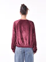 Campera negra de terciopelo con cierre frontal y apliques de lentejuelas plateadas.
