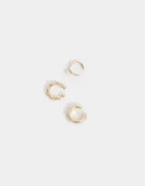 Set de tres earcuffs dorados con diferentes diseños: uno liso, uno texturizado y uno con una perla.