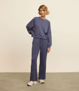 Buzo deportivo femenino confeccionado en microfibra color azul, con cuello redondo, mangas raglán largas y recortes.