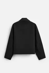 Sudadera negra de corte relaxed fit, con cuello alto y cierre frontal de cremallera metálica.