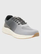 Zapatillas grises de tejido de punto con cordones, suela blanca y puntera marrón.