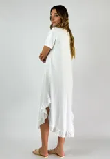 Vestido midi lila con textura arrugada, corte holgado, mangas cortas y ruedo con volados.