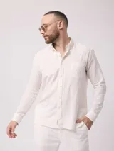 Camisa de manga larga azul, de lino y poliéster, con cuello abotonado y bolsillo en el pecho.