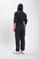 Mono largo de jean negro con corte holgado, mangas largas y cuello camisero.