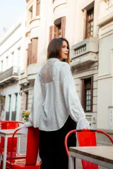 Camisa color beige con encaje en la parte delantera y en las mangas, de corte holgado.