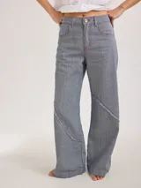 Pantalón largo de tiro medio alto a rayas verticales azules y blancas con costuras rojas a contratono. Presenta bolsillos delanteros y traseros, y cortes con desflecado.