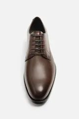 Zapato de vestir marrón tipo derby, con parte superior lisa, horma en punta y suela con ligero tacón.