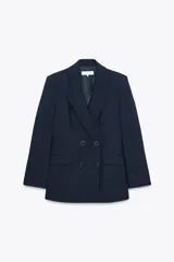 Blazer azul marino de cuello solapa y manga larga. Tiene bolsillos con solapa en delantero y cierre frontal con doble botonadura.