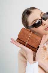 Billetera tipo sobre de cuero negro con cierre de elástico, separaciones internas y bolsillo con cierre para monedas.