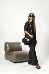 Cartera bandolera negra de nylon con detalles en charol, grifa de goma y cordones combinados. Tiene correa regulable e intercambiable.