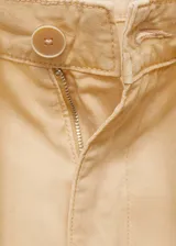 Pantalón color beige de tiro medio y corte ancho, con bolsillos laterales, bolsillos cargo y bolsillos de parche en la parte posterior.
