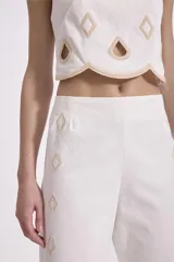 Conjunto de top crop y pantalón palazzo negros con bordados calados en forma de rombos con borde festoneado en color crudo.