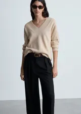 Sweater color beige de tejido de punto con cuello en V y corte oversize.