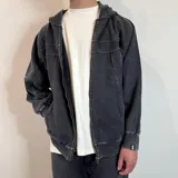 Campera con capucha de algodón color gris oscuro con efecto lavado y cierre frontal. Tiene bolsillos laterales y puños ajustados.
