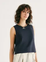 Blusa verde sin mangas, de corte recto y cuello redondo.