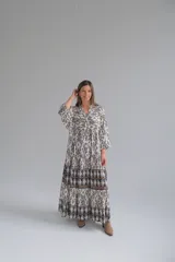 Vestido largo con estampado geométrico en blanco y negro, con mangas 3/4 y cuello en V.