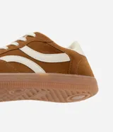 Championes de estilo chuteira, color marrón con recortes y detalles en color crema. Presentan cordones blancos y suela baja de goma color caramelo.