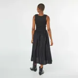 Vestido midi negro con corte imperio, falda amplia y musculosa con escote redondo.