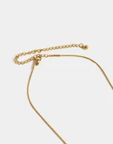 Cadena dorada con dije de corazón calado con incrustaciones de perlas.