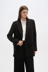 Blazer negro de corte holgado, con cuello solapa, cierre con doble botón y bolsillos laterales con solapa.
