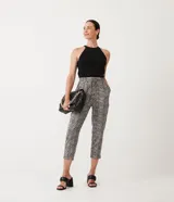 Pantalón capri con estampado tipo tweed en tonos blanco, negro y gris. Tiene corte recto, cintura alta con lazo y bolsillos laterales.
